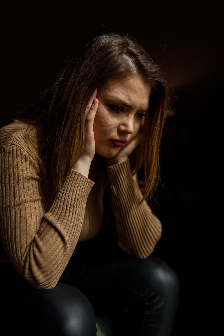 Mujer con ansiedad apoyando la cabeza en la mano